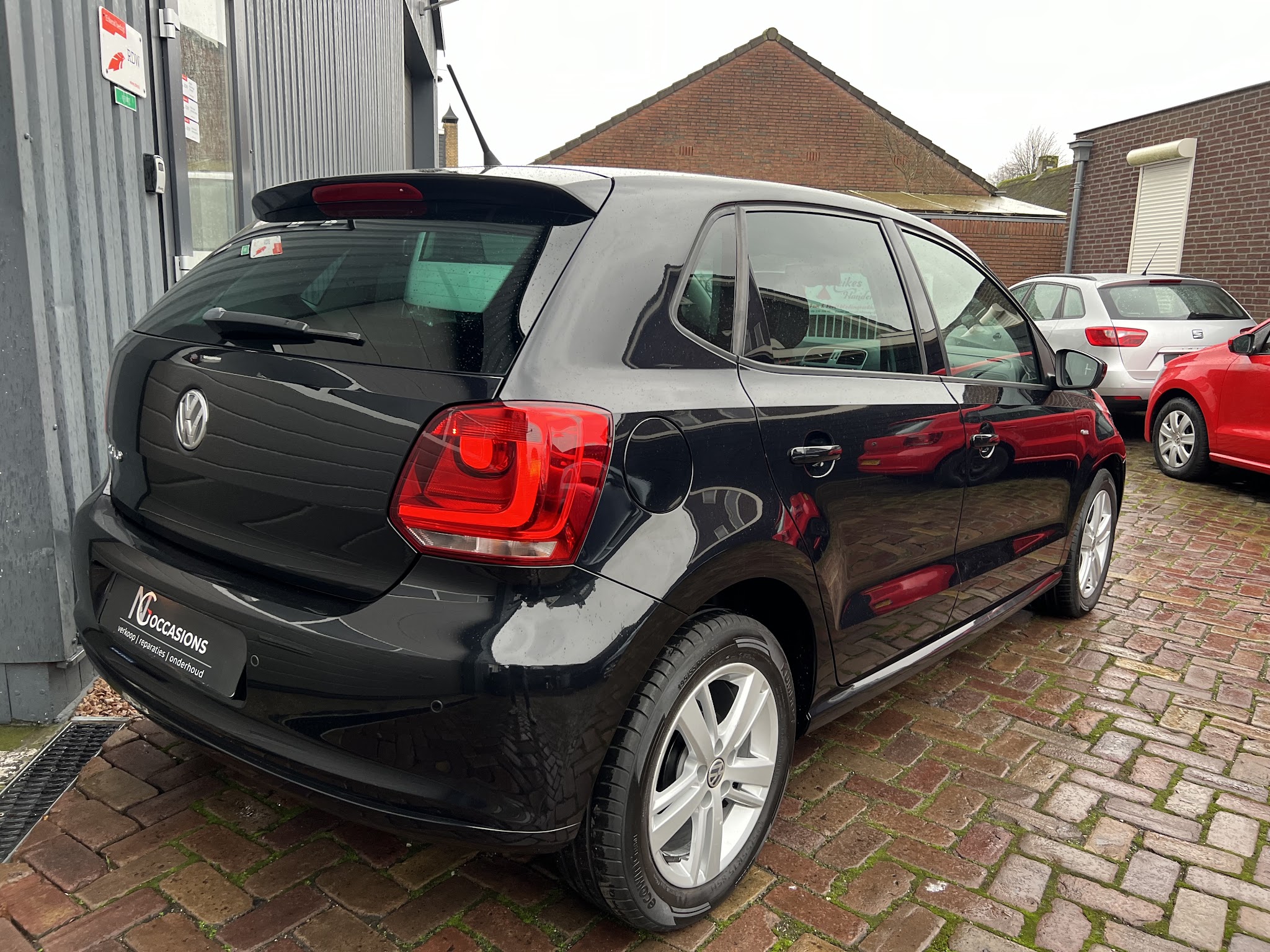 Het terrein van NG Occasions met meerdere auto's naast de werkplaats
